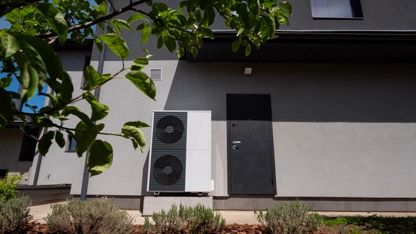 Façade extérieure d'habitation moderne avec pompe à chaleur air-eau installée