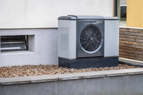 Un technicien en tenue de travail effectue la maintenance d'un système de chauffage dans un local technique moderne